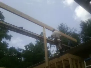 Carpenter setting a ridge beam over a new addition frame — Ice Dam Removal by Roofing Brothers in Mount Laguna