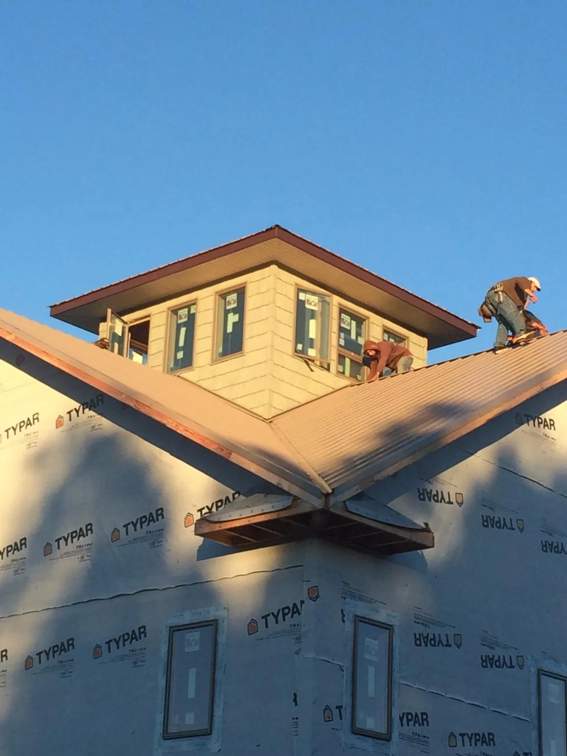 Roofers working around a rooftop cupola on a new metal roof at sunset — Roof Waterproofing in Mount Laguna by Roofing Brothers